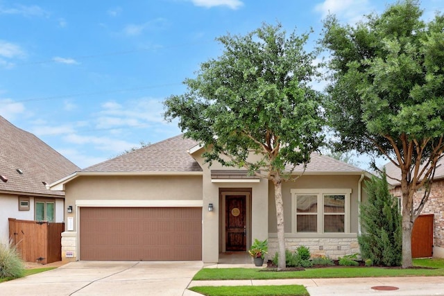 view of front of property featuring a garage, stucco siding, driveway, and fence