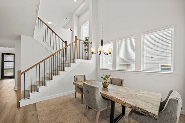 991 Hazy Hills Loop, Dripping Springs, TX 78620 - dining area with a towering ceiling, wood finished floors, baseboards, an inviting chandelier, and stairs