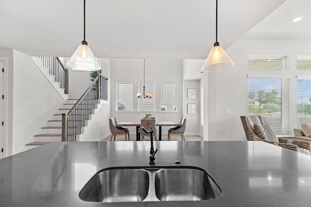 991 Hazy Hills Loop, Dripping Springs, TX 78620 - kitchen featuring hanging light fixtures, dark countertops, a chandelier, and a sink