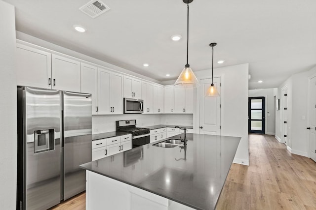 991 Hazy Hills Loop, Dripping Springs, TX 78620 - kitchen featuring dark countertops, a sink, stainless steel appliances, white cabinetry, and visible vents