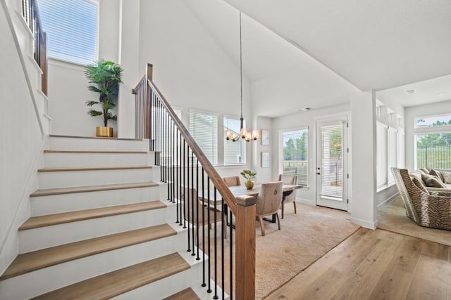 991 Hazy Hills Loop, Dripping Springs, TX 78620 - stairs with wood-type flooring, baseboards, vaulted ceiling, and an inviting chandelier