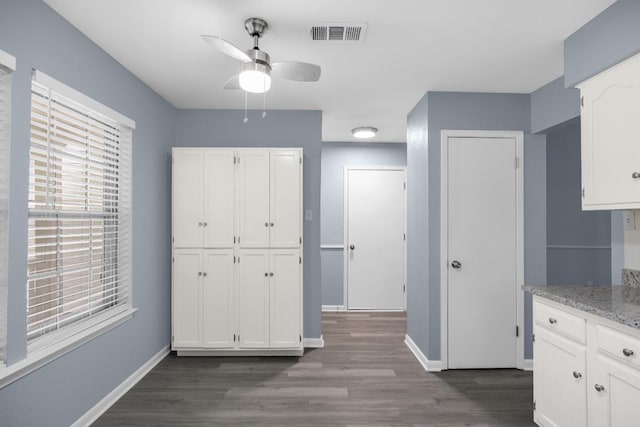 4411 Cumbria Ln, Austin, TX 78727 - kitchen featuring ceiling fan, white cabinets, dark wood-type flooring, and light stone countertops