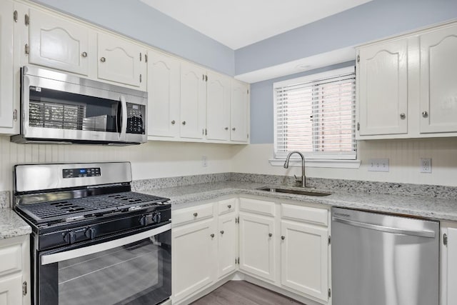 4411 Cumbria Ln, Austin, TX 78727 - kitchen featuring stainless steel appliances, white cabinetry, and light stone counters