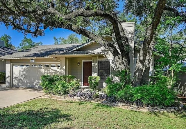 view of front of house featuring a garage, driveway, and a front yard
