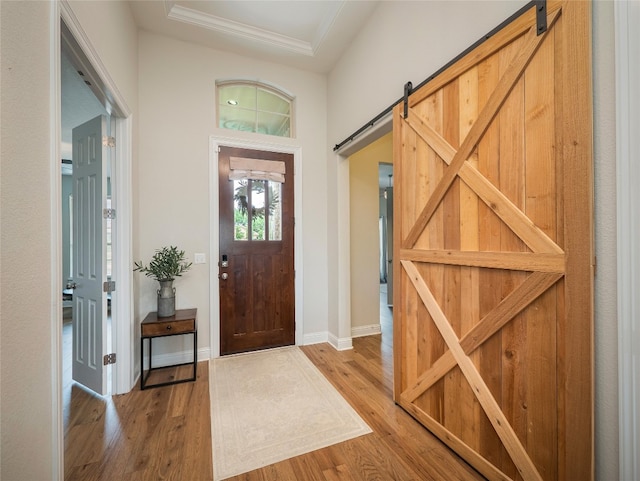 105 Strata Dr, Liberty Hill, TX 78642 - entryway featuring baseboards, ornamental molding, a barn door, and wood finished floors