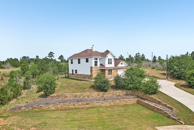 exterior space with a front lawn, driveway, and a chimney