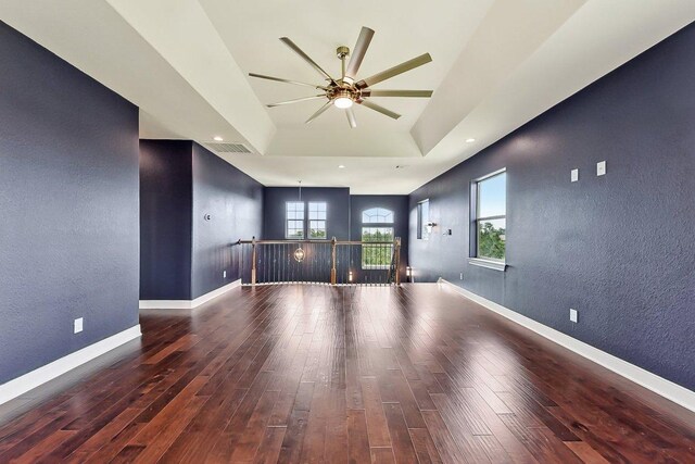 spare room with plenty of natural light, a textured wall, a ceiling fan, and wood finished floors