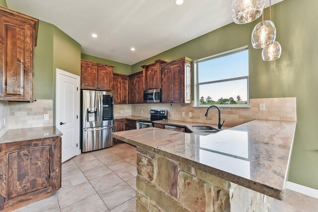 kitchen with a sink, decorative backsplash, light stone countertops, and stainless steel appliances
