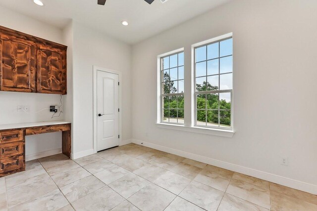 unfurnished dining area featuring built in study area, baseboards, ceiling fan, and recessed lighting
