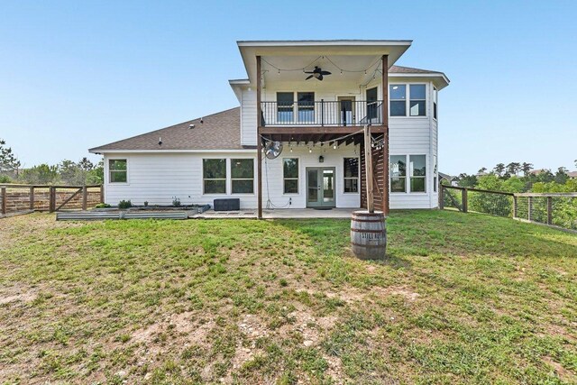 back of house featuring french doors, ceiling fan, a fenced backyard, a lawn, and a patio