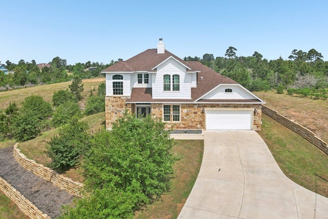 traditional home featuring fence, stone siding, a garage, a chimney, and concrete driveway