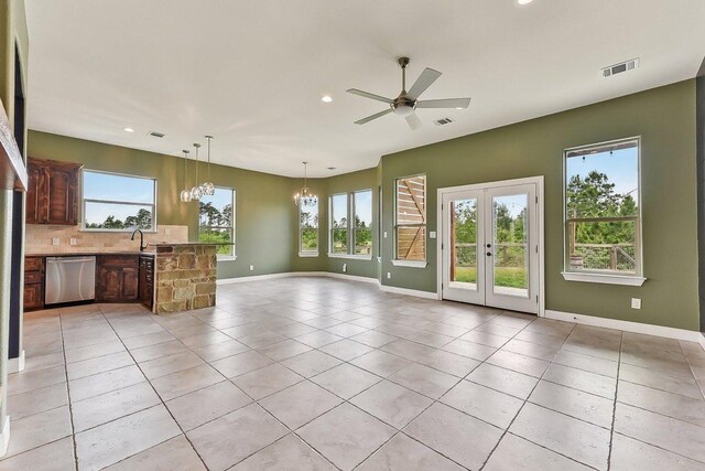 unfurnished living room featuring a wealth of natural light, ceiling fan with notable chandelier, recessed lighting, and visible vents