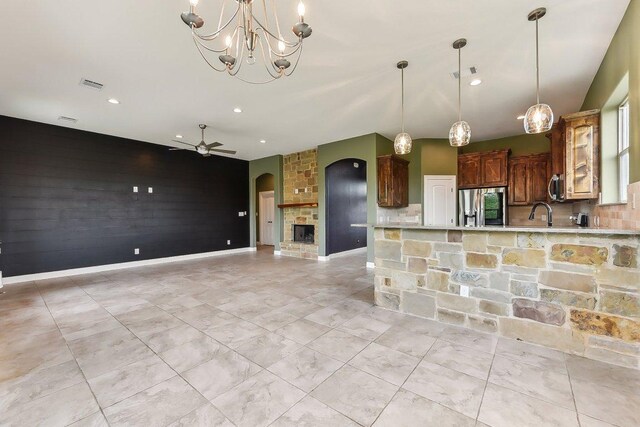kitchen featuring stainless steel refrigerator with ice dispenser, light countertops, ceiling fan with notable chandelier, and visible vents