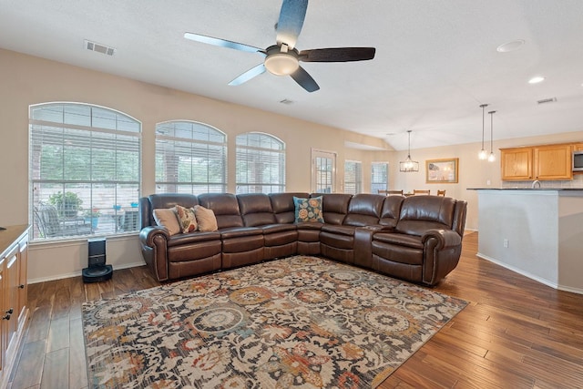 living area with wood-type flooring, ceiling fan, visible vents, and a wealth of natural light