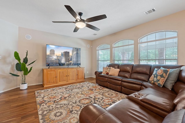 living area with visible vents, baseboards, ceiling fan, and wood finished floors