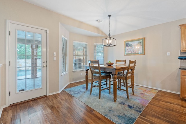 dining area with visible vents, baseboards, wood finished floors, and a chandelier