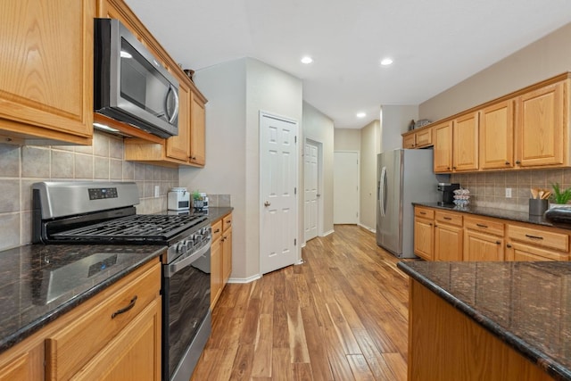 kitchen with backsplash, light wood-type flooring, baseboards, stainless steel appliances, and recessed lighting