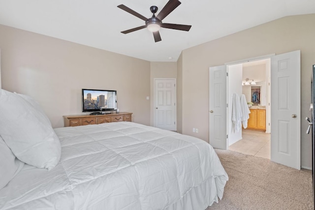 bedroom featuring ceiling fan, light colored carpet, vaulted ceiling, ensuite bathroom, and light tile patterned flooring