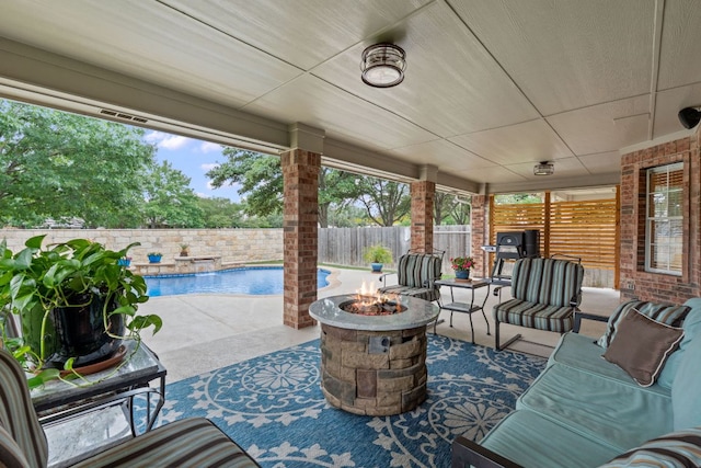 view of patio / terrace featuring a fenced in pool, a fenced backyard, and a fire pit
