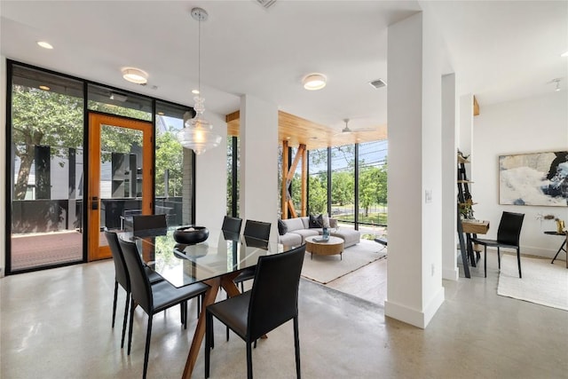 dining space featuring baseboards, concrete floors, and expansive windows