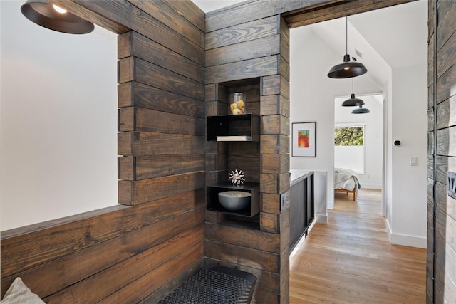 corridor featuring baseboards and wood finished floors