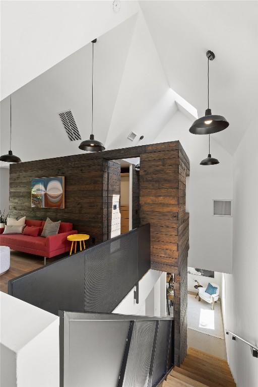 interior space with visible vents, lofted ceiling, and wood finished floors