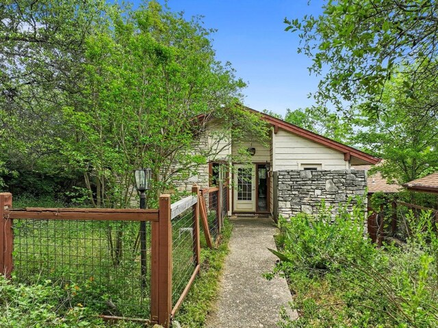 exterior space with fence and stone siding