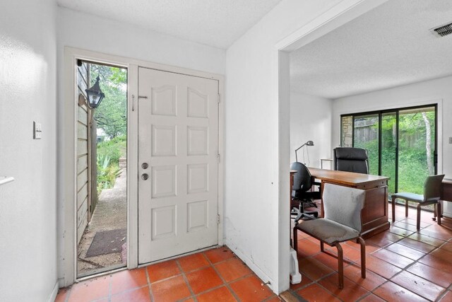 entrance foyer featuring tile patterned floors, visible vents, and plenty of natural light
