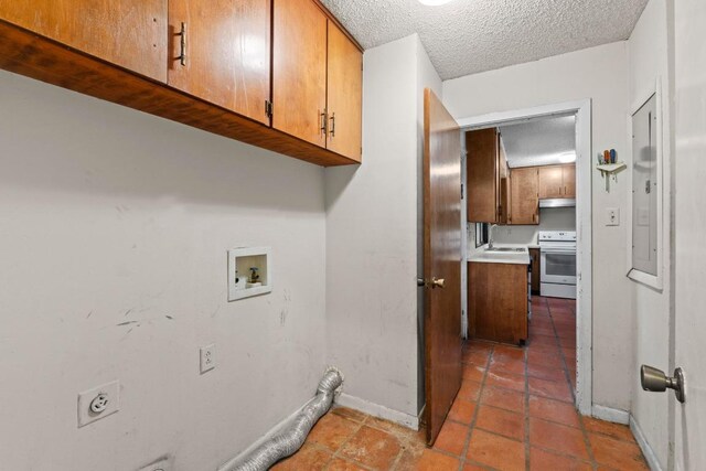 laundry area with baseboards, a textured ceiling, electric dryer hookup, cabinet space, and washer hookup