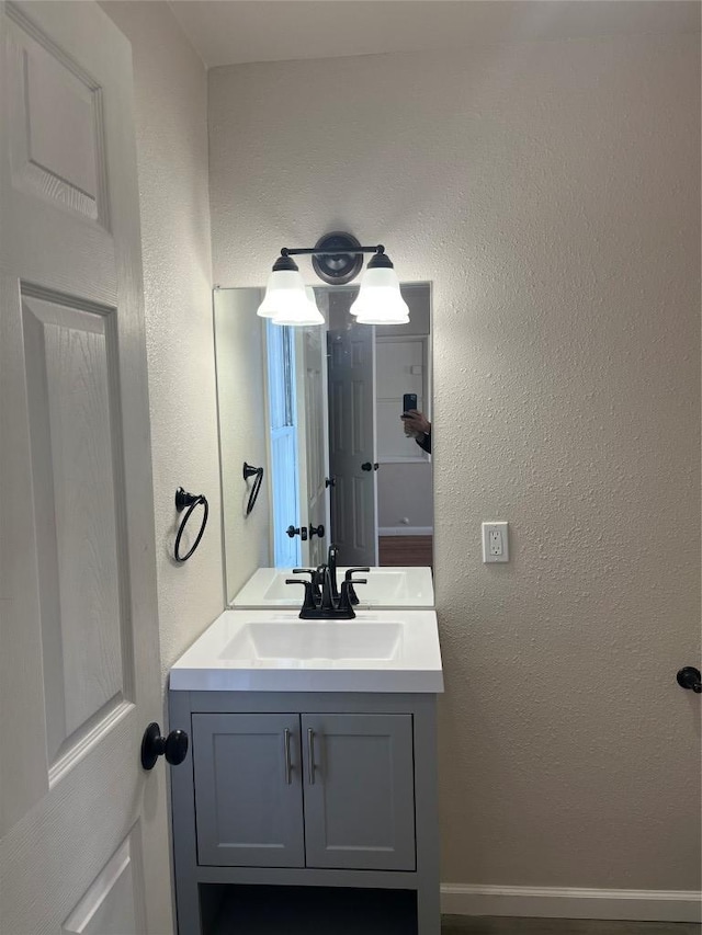 bathroom with vanity and a textured wall