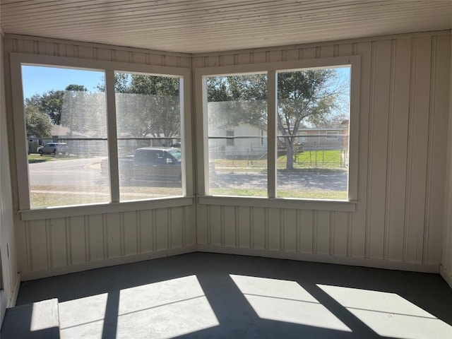 unfurnished sunroom featuring concrete flooring and a wealth of natural light