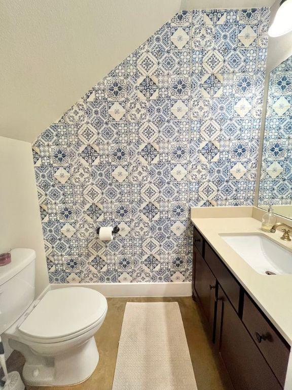 923 Debco Ln, Spicewood, TX 78669 - bathroom featuring toilet, wallpapered walls, and vanity