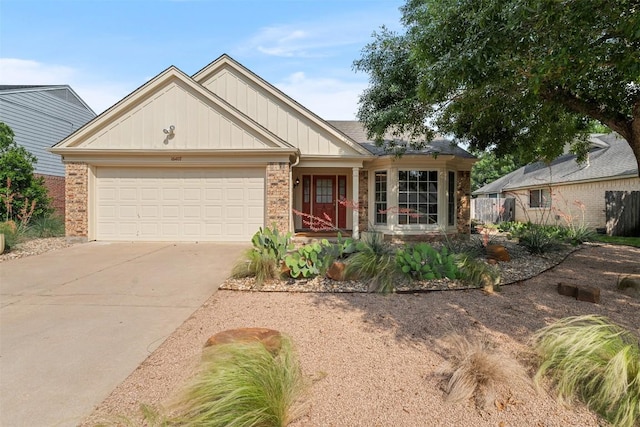 ranch-style home with an attached garage, board and batten siding, brick siding, and concrete driveway