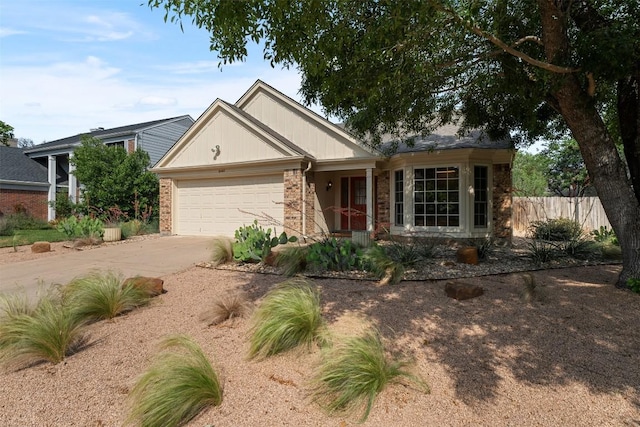 ranch-style home featuring an attached garage, fence, driveway, and brick siding