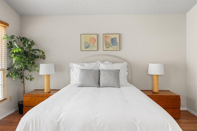 bedroom featuring baseboards and wood finished floors