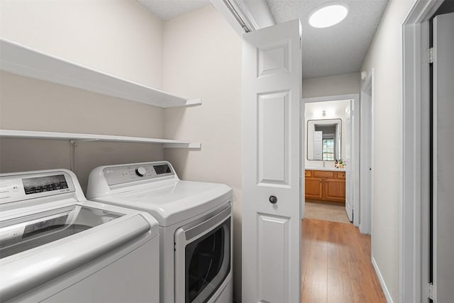 washroom with independent washer and dryer, laundry area, baseboards, and light wood-type flooring