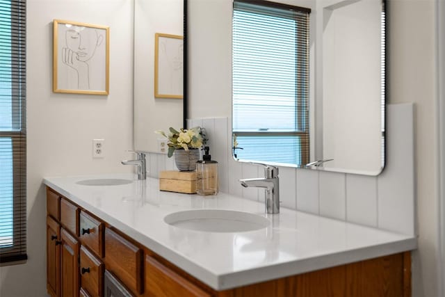 bathroom featuring double vanity, a sink, and a healthy amount of sunlight