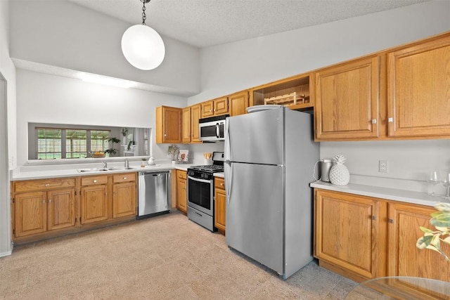 kitchen with brown cabinetry, light countertops, appliances with stainless steel finishes, and hanging light fixtures