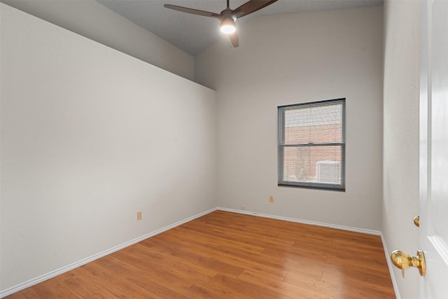 empty room featuring a ceiling fan, baseboards, vaulted ceiling, and light wood finished floors