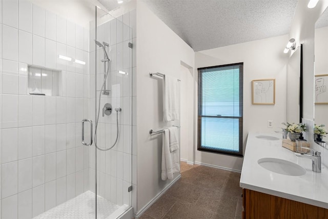 bathroom featuring double vanity, baseboards, a shower stall, and a sink