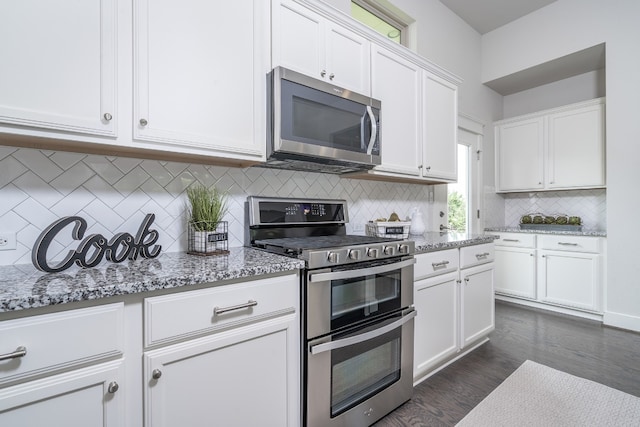 1766 Rowdy Loop, Leander, TX 78641 - kitchen with decorative backsplash, light stone counters, white cabinets, dark wood-style floors, and stainless steel appliances