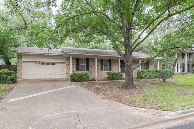 single story home with brick siding, driveway, and a garage