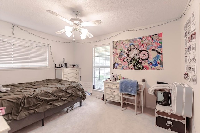 bedroom featuring ceiling fan, carpet flooring, and a textured ceiling