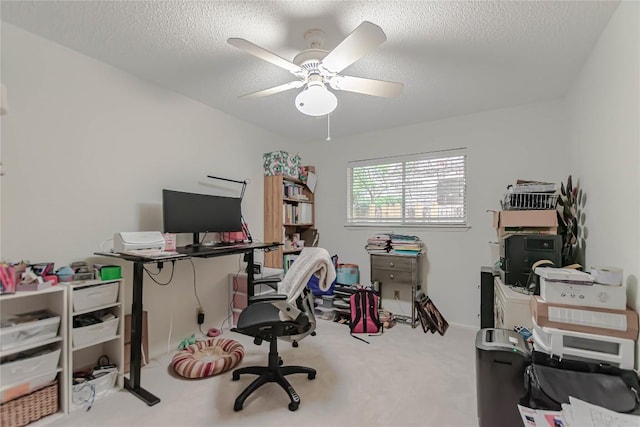 carpeted office space featuring a ceiling fan and a textured ceiling