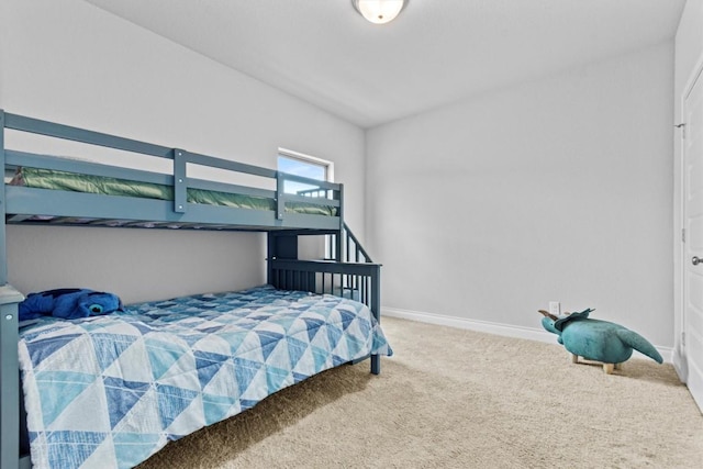 bedroom featuring baseboards, carpet, and vaulted ceiling