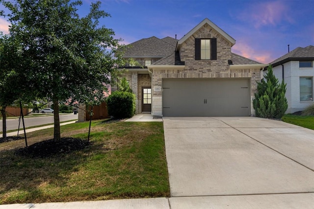 traditional-style house featuring brick siding, an attached garage, roof with shingles, and concrete driveway