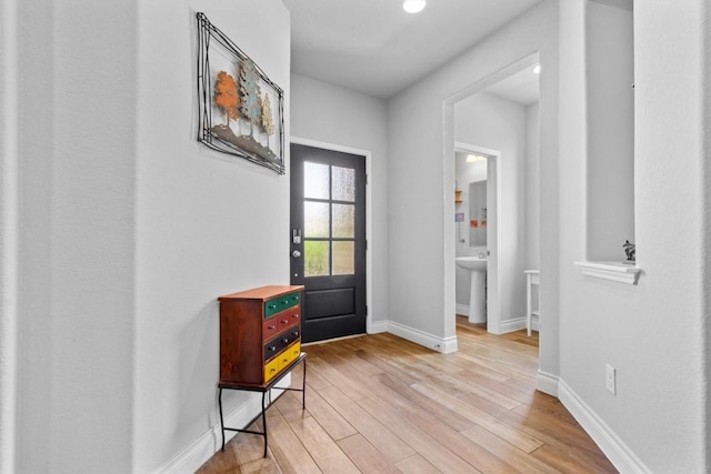 doorway to outside with light wood-style floors and baseboards