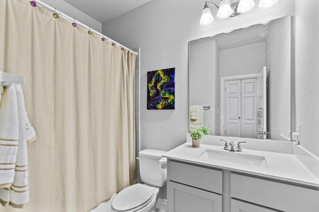 full bathroom with vanity, a textured wall, toilet, and curtained shower