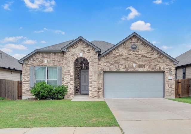french country inspired facade with brick siding, a garage, fence, and a front yard