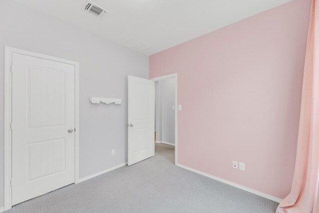 unfurnished bedroom with baseboards, visible vents, and carpet